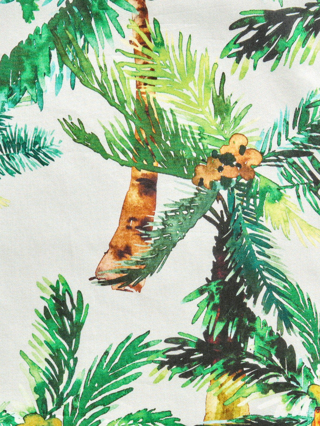 Green tropical palm print pareo made from a cotton-silk blend, designed as a beach cover-up or resort wrap.
